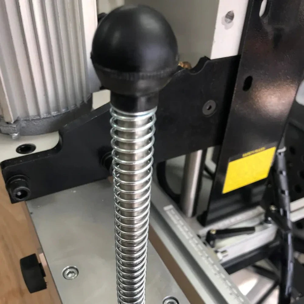 Return spring mechanism on drill carriage for smooth vertical travel