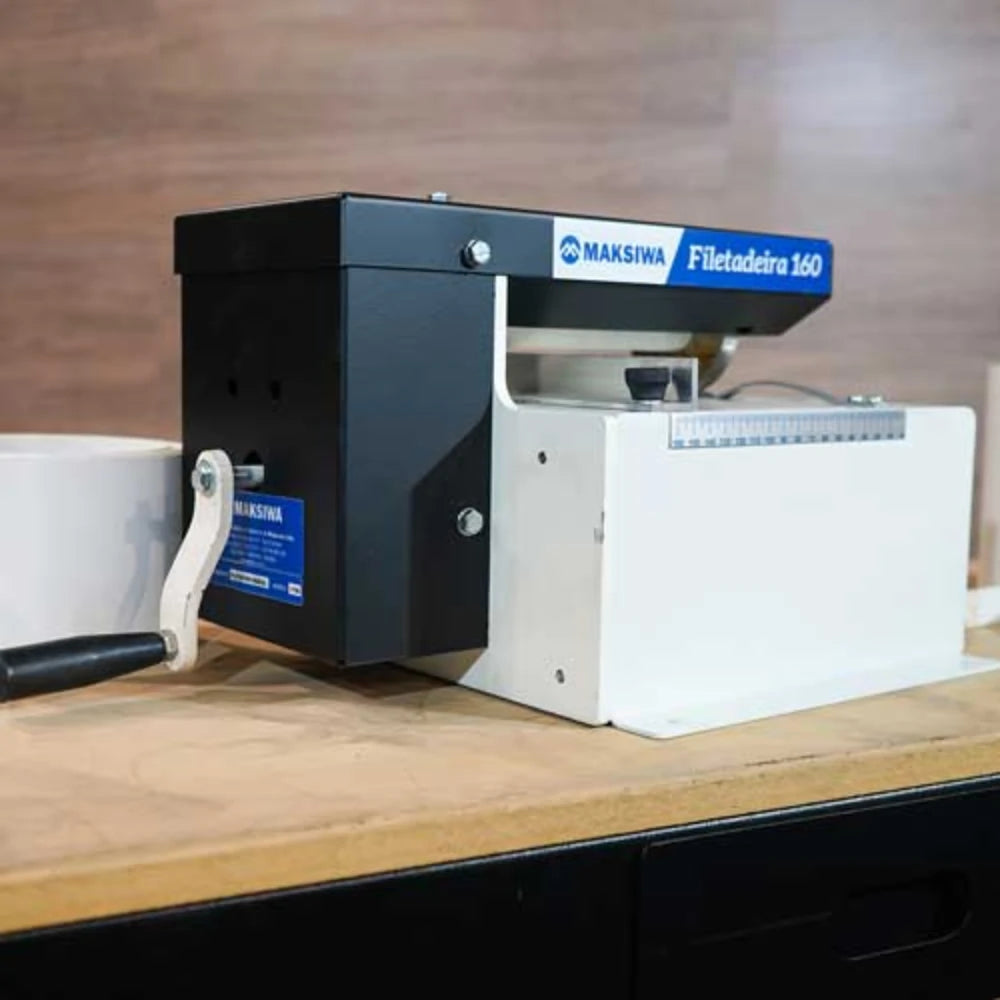 Operator feeding edging strips through slitter in woodworking shop