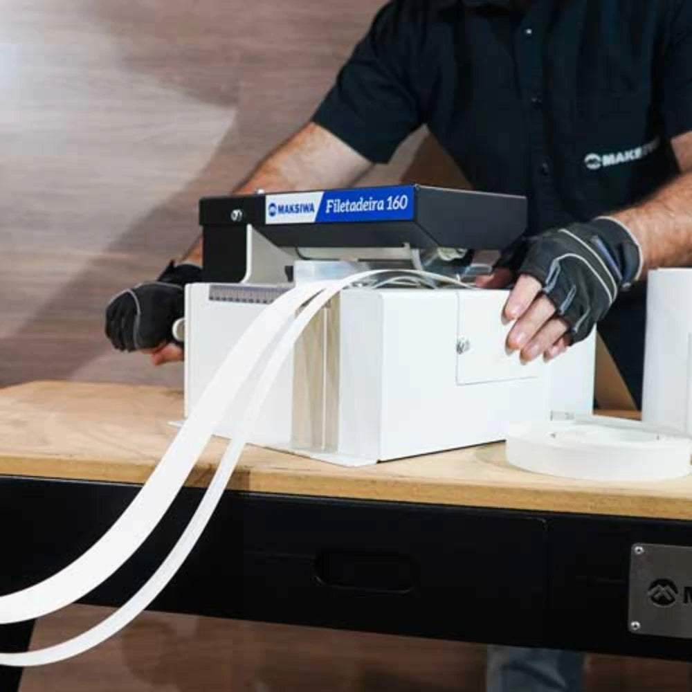 Manual slitter trimming edge banding rolls beside workbench setup